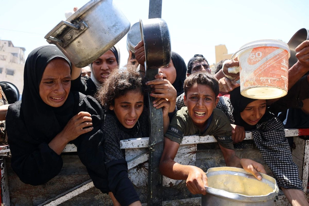 Palestinos esperan para recibir alimentos en un punto de distribución en la ciudad de Gaza.
