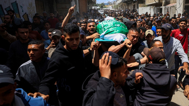 La gente transporta un cuerpo identificado por los dolientes como el del comandante del ala militar de Hamás, Izz al-Din al-Haddad.