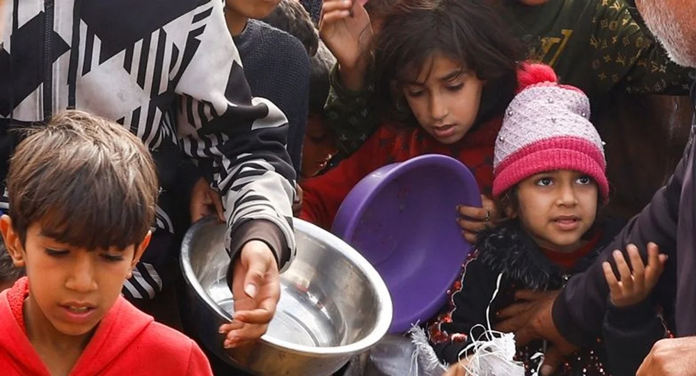 Niños palestinos esperan recibir alimentos. Foto: Reuters