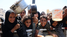 Palestinos esperan para recibir alimentos en un punto de distribución en la ciudad de Gaza.